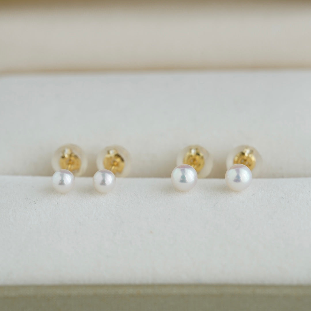 Handmade Japanese Akoya pearl stud earrings with gold backs, displayed on a soft white surface.