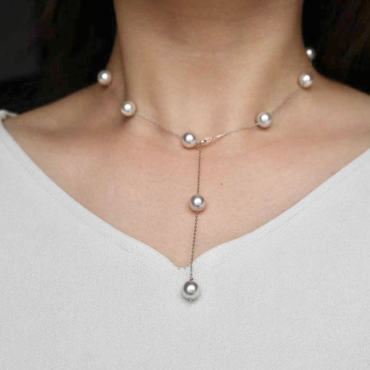 Elegant Japanese Akoya pearl necklace with delicate chain and lariat drop, showcasing luminous seawater pearls.