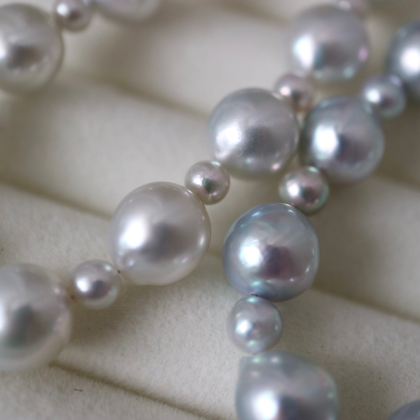 Lustrous Japanese Akoya pearl necklace with round, high-luster pearls on soft fabric