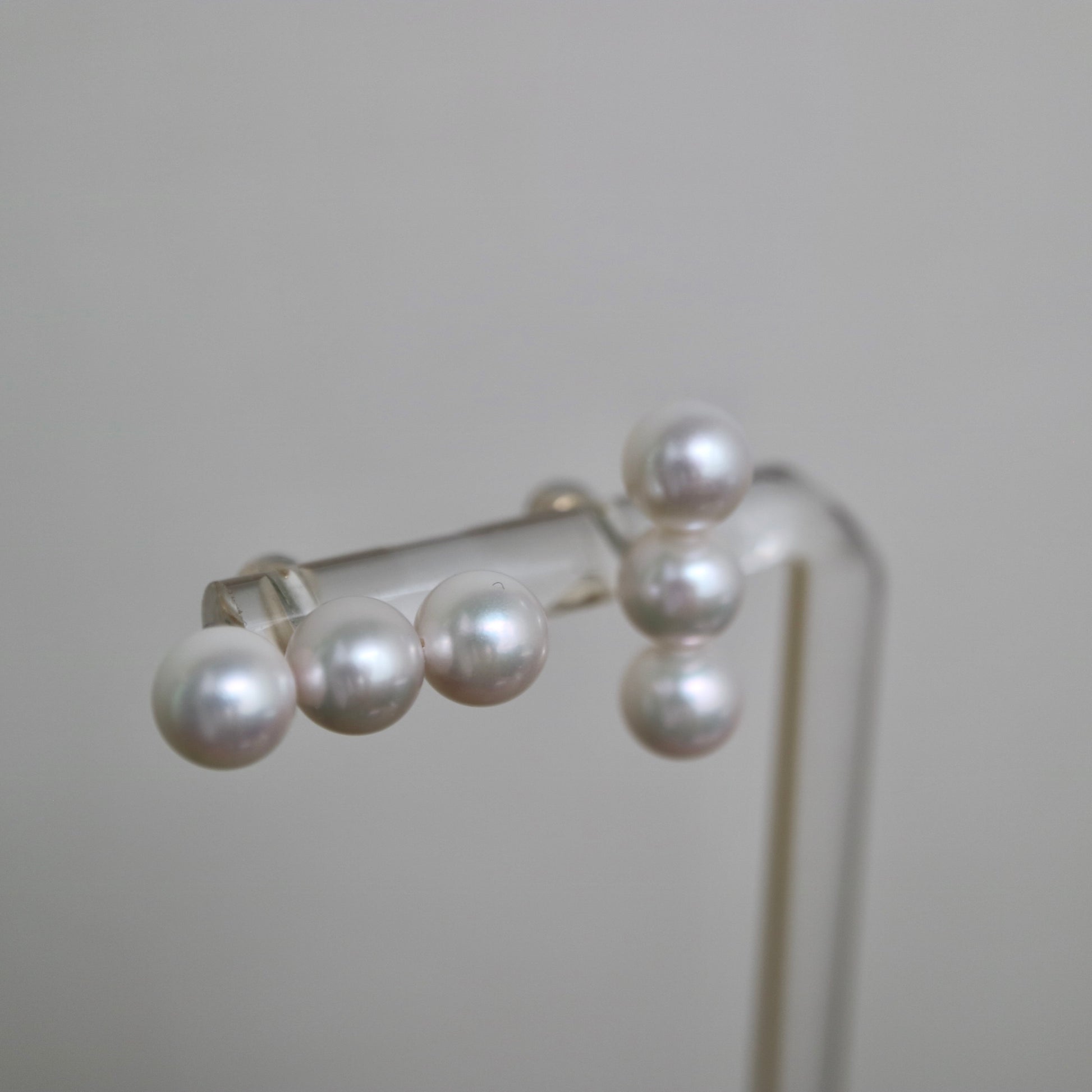 Lustrous Japanese Akoya pearl earrings, hand-selected seawater pearls on display stand