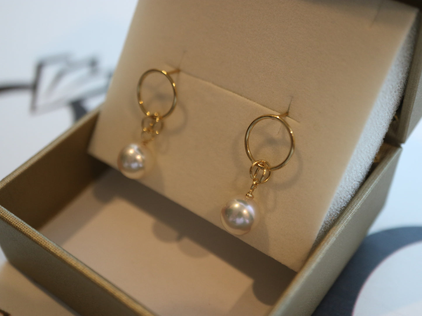 Handmade gold hoop earrings with Akoya pearls in a cream jewelry box