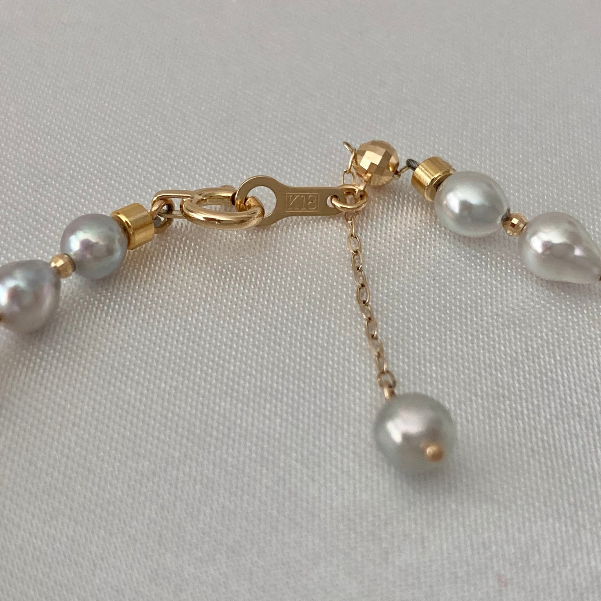 Elegantなアコヤ真珠のネックレス。金色の留め具と長さ調節可能なチェーン付きで、艶やかな真珠と上質な職人技が際立ちます。