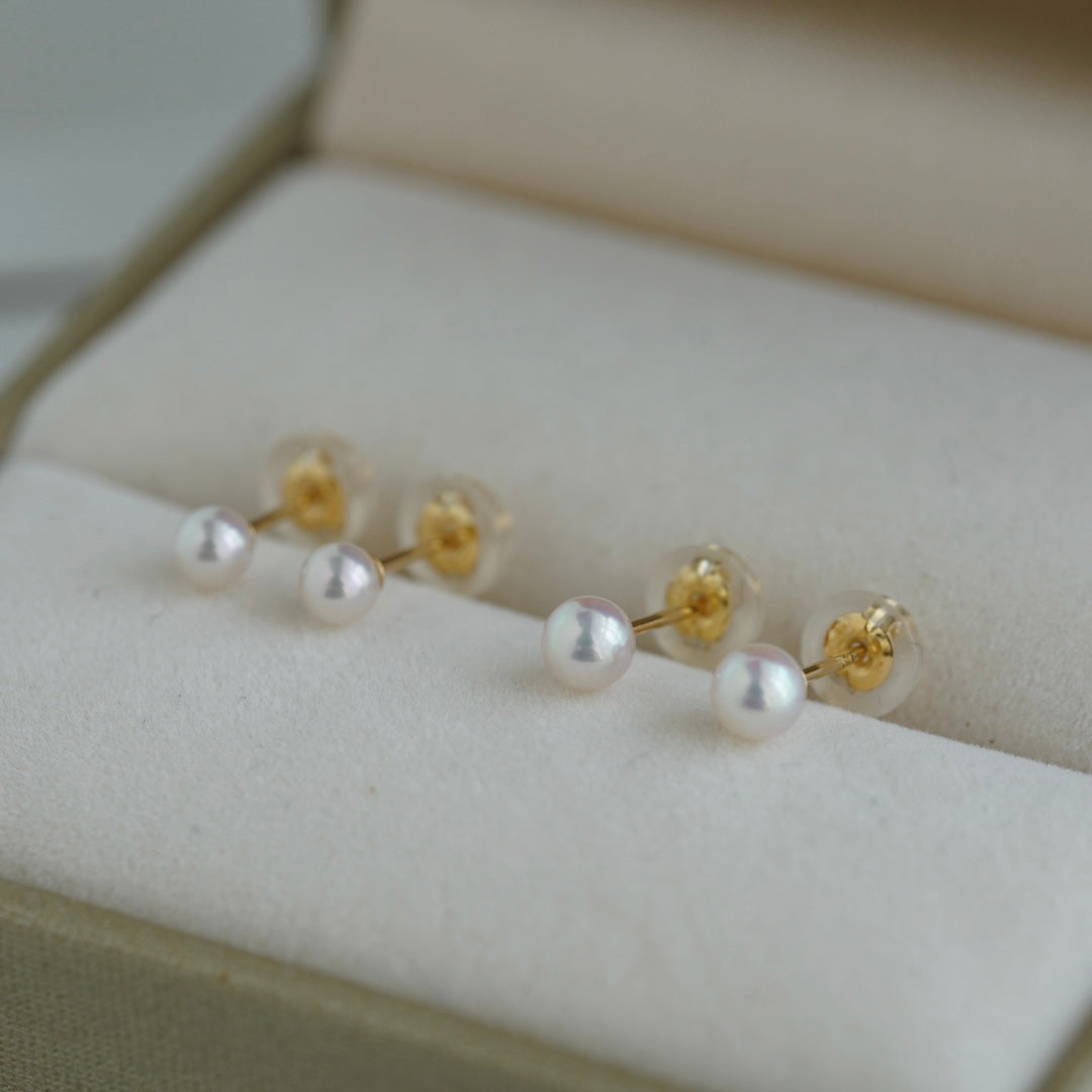 Elegant Akoya pearl earrings with gold posts, displayed in a soft jewelry box