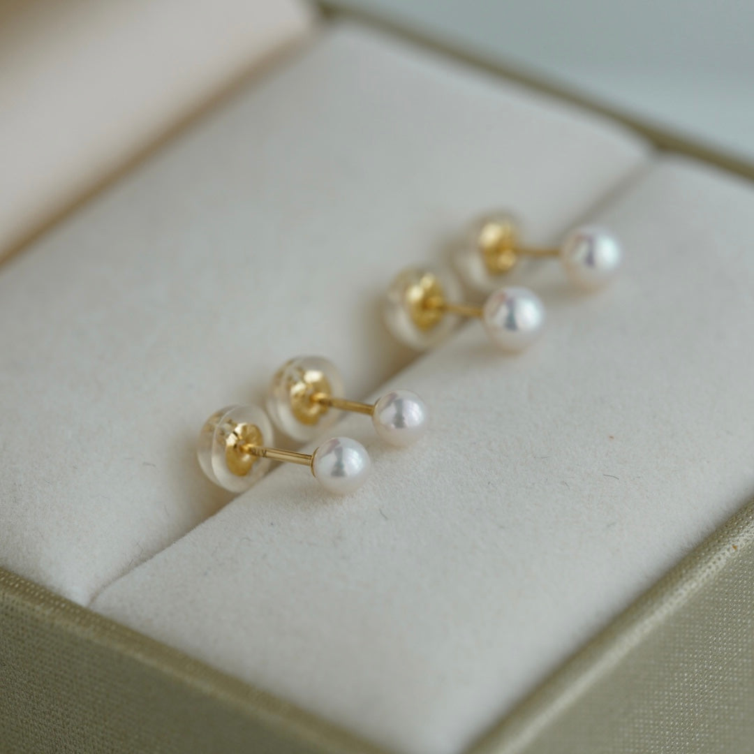 Handmade Japanese Akoya pearl stud earrings in gold setting, displayed in luxury box