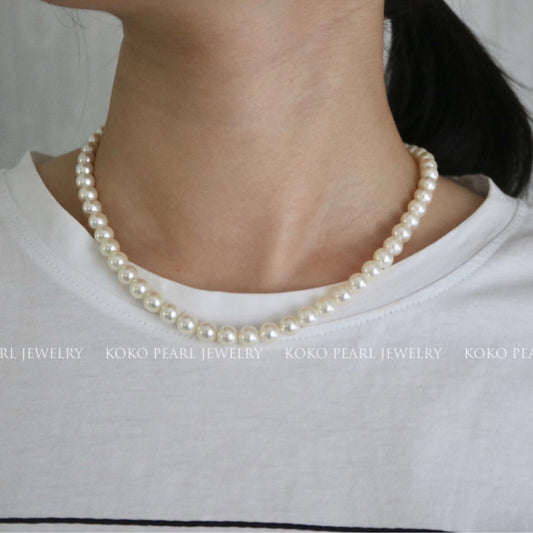 Handmade Japanese Akoya pearl necklace worn on neck, showcasing lustrous seawater pearls with natural shine.
