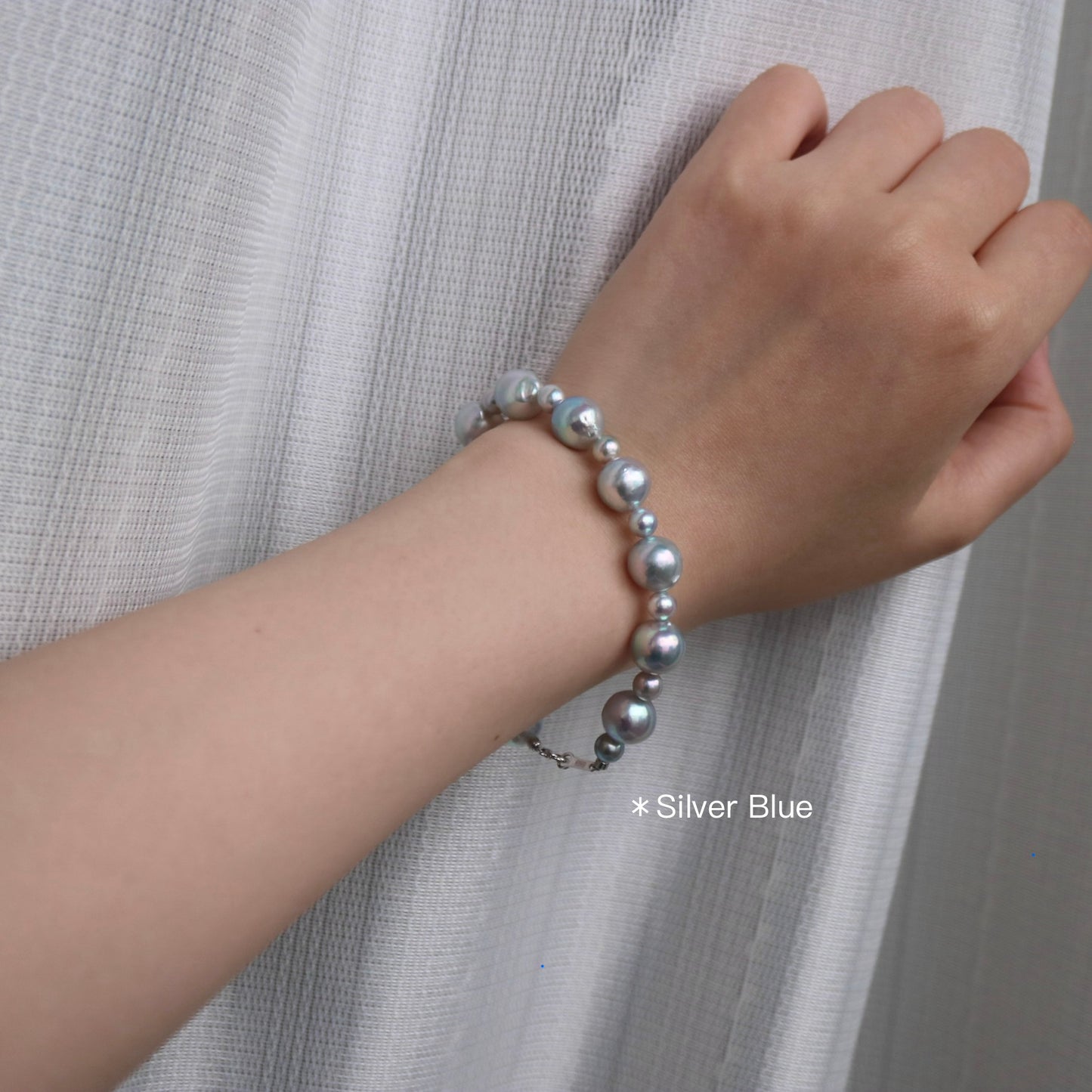 Silver blue Akoya pearl bracelet on wrist, handmade Japanese seawater pearls, elegant and lustrous