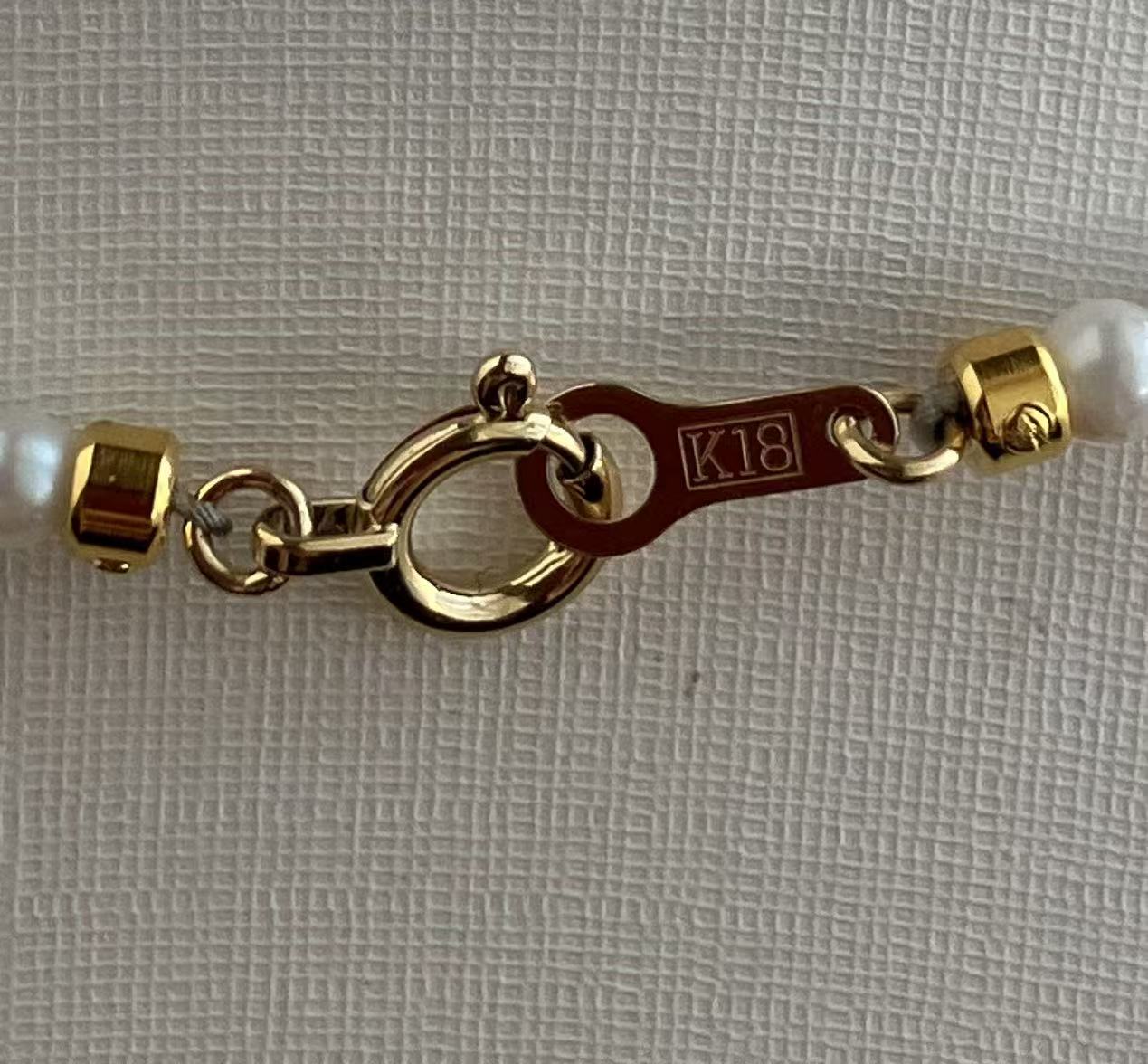18K gold clasp on Japanese Akoya pearl bracelet, K18 hallmark visible, handmade luxury jewelry