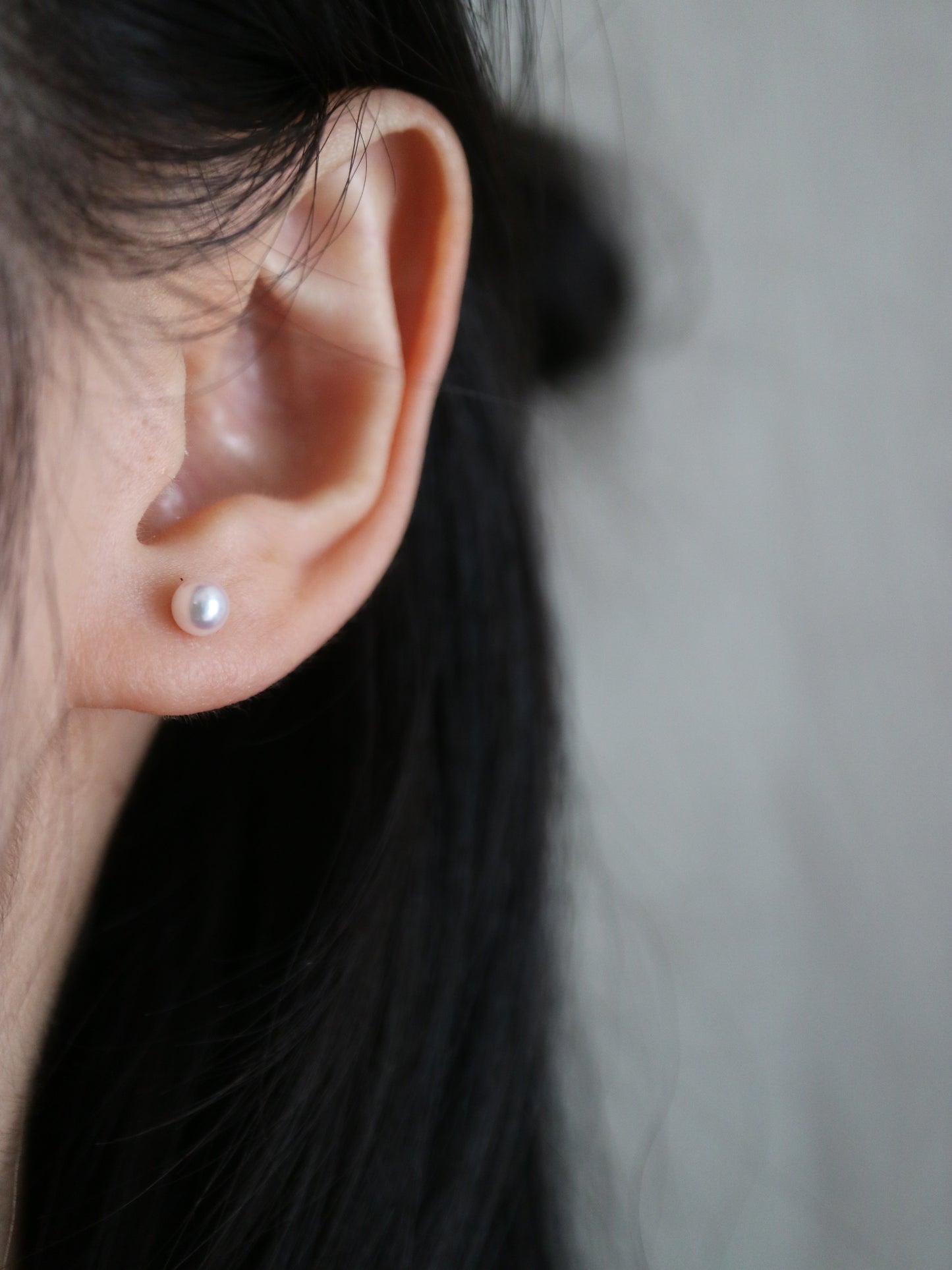 Elegant Akoya pearl stud earring on ear, showcasing lustrous seawater pearl for timeless jewelry