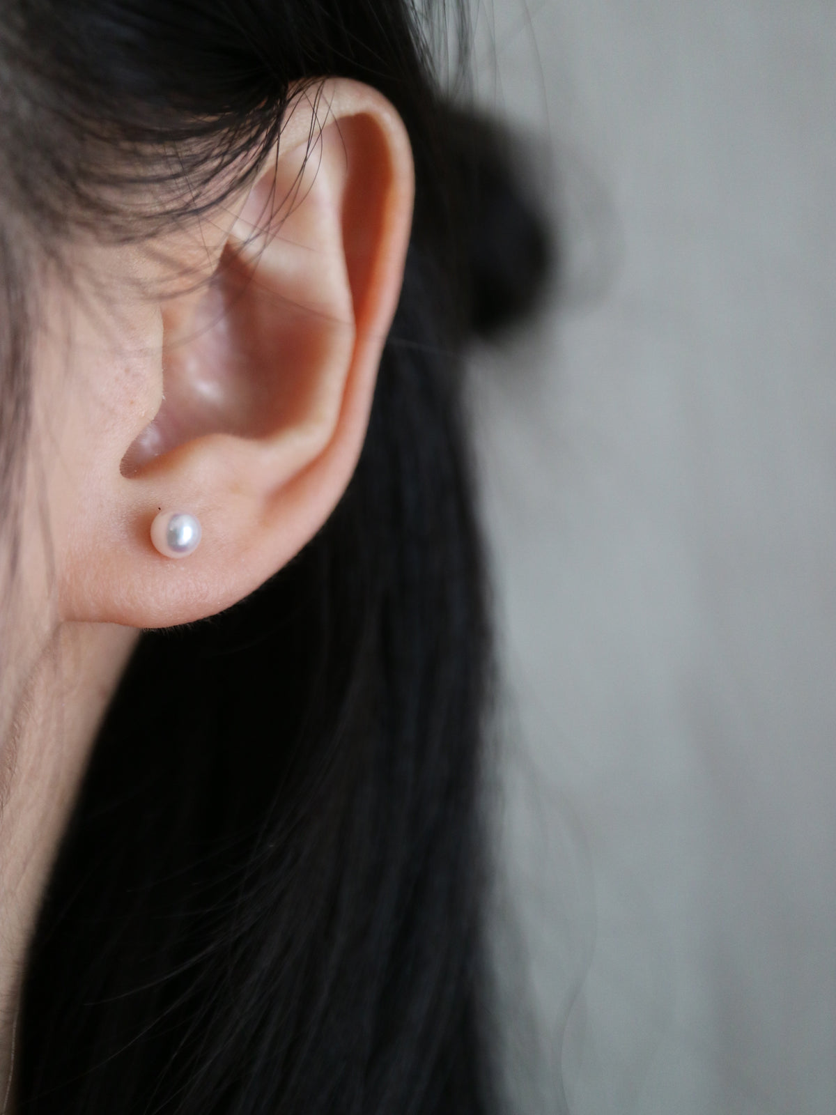 Elegant Akoya pearl stud earring on ear, showcasing lustrous seawater pearl for timeless jewelry