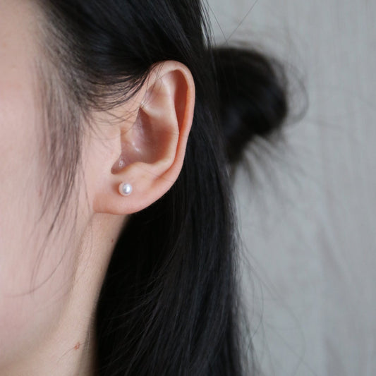 Elegant Akoya pearl earring on ear, showcasing lustrous seawater pearl for timeless jewelry style