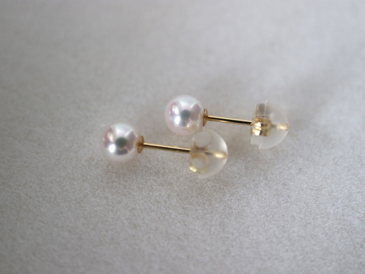 Elegant Akoya pearl stud earrings with gold posts, showcasing lustrous seawater pearls on a soft background.